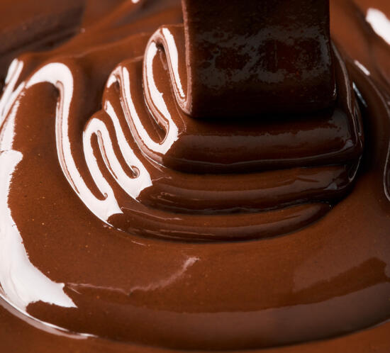 Crema de xocolata fluint sobre superfície, fotografia xocolata líquida producte per Alex Tremps